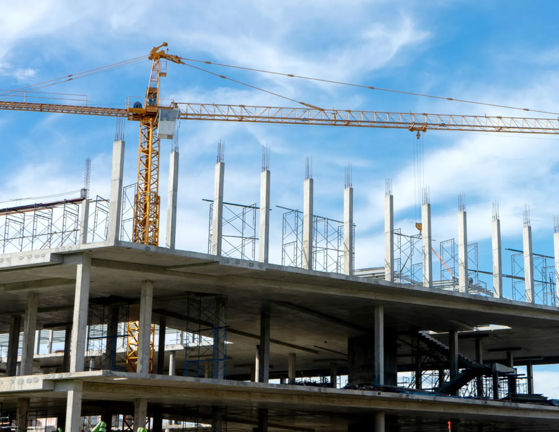 Tower crane over a concrete frame against the sky, seen from above