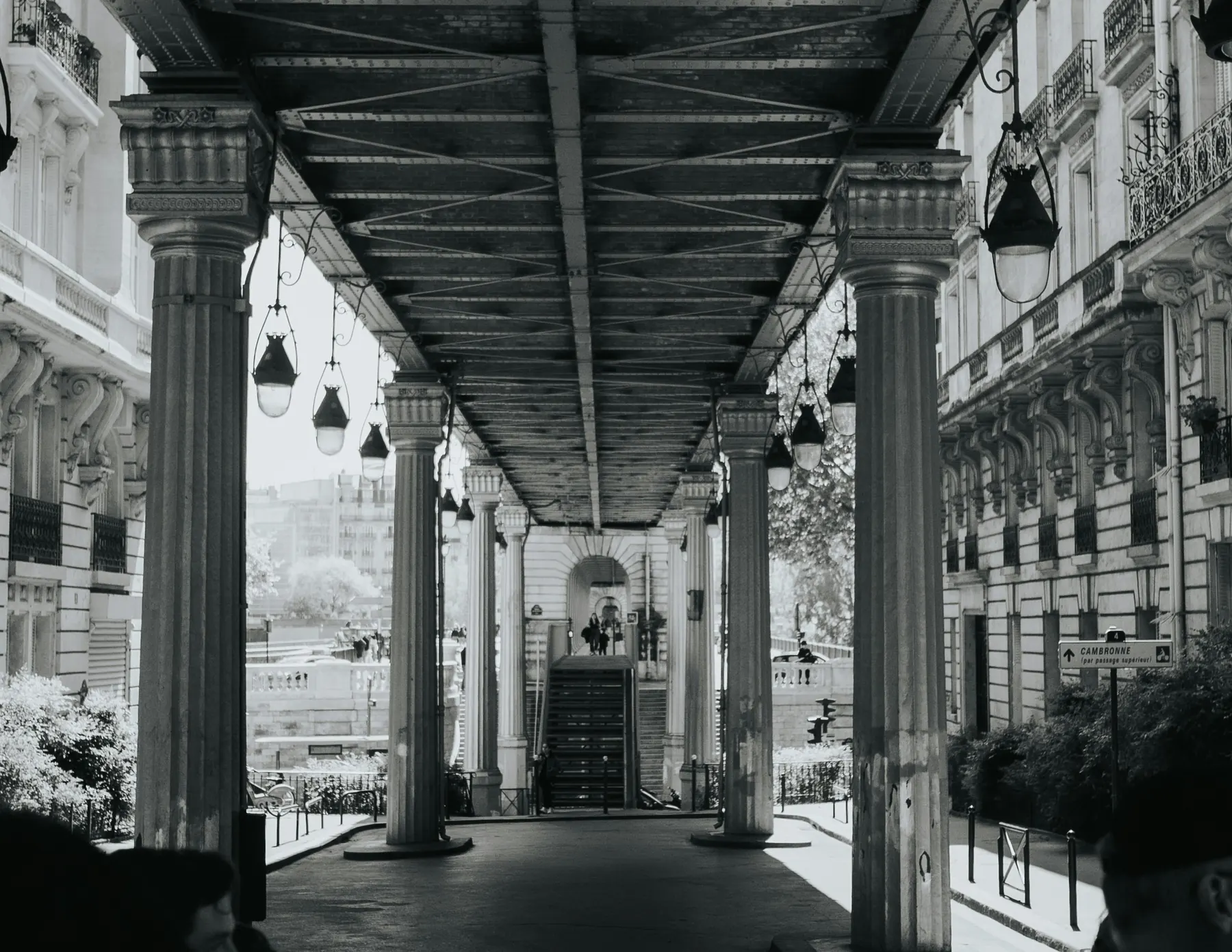 Black and white view down a colonnade of carved stone columns